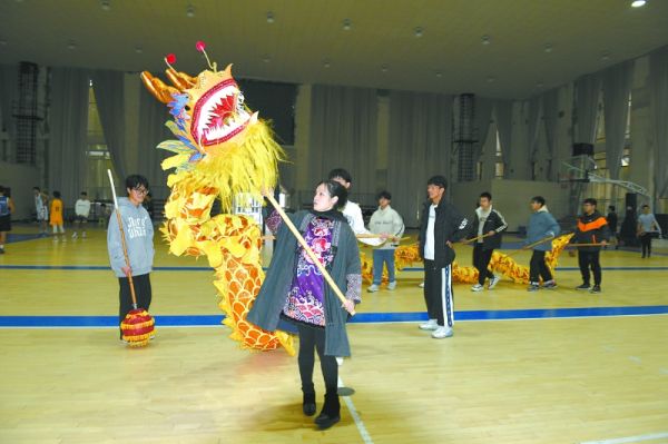 李晓艳向舞龙队员传授金龙舞技艺。文仁萍摄