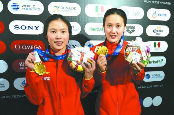 掌敏洁/卢为（左）在颁奖仪式后展示奖牌。新华社发（迪亚娜·马克斯摄）